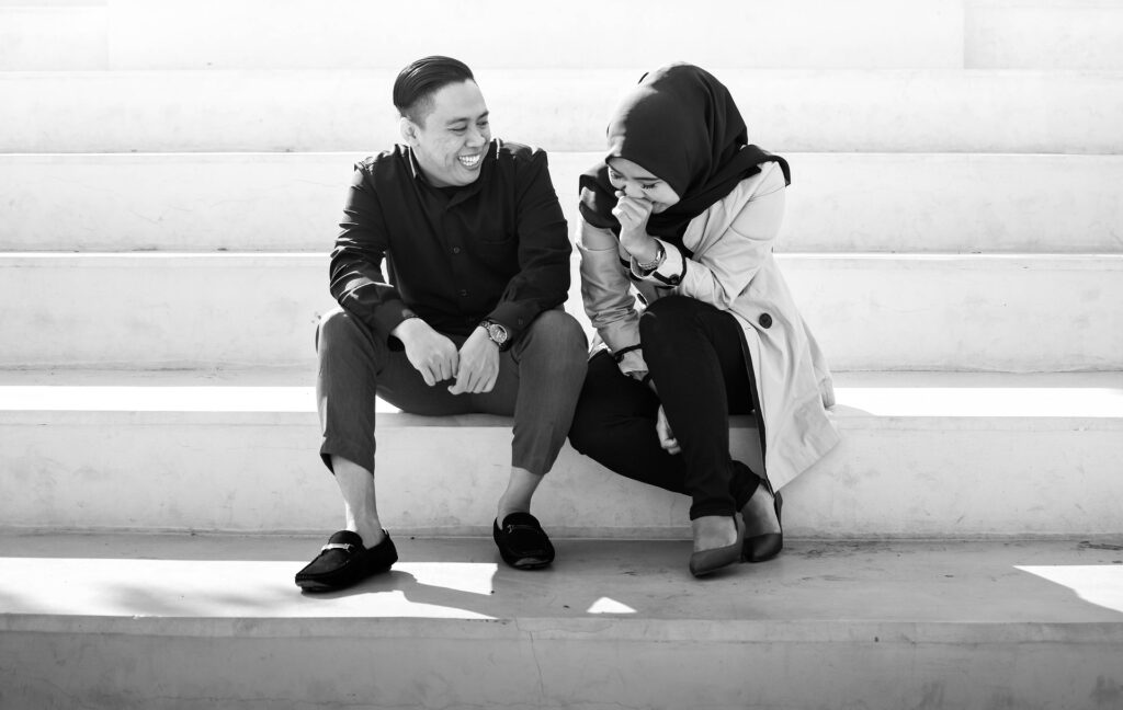 casal sentado em uma escada na rua conversando e rindo durante encontro