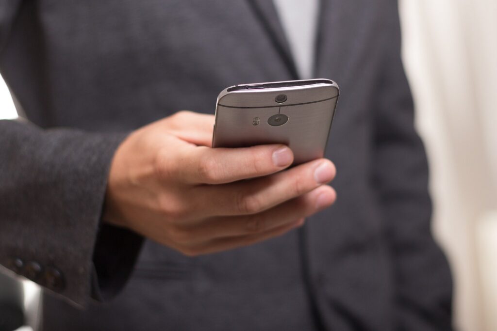 homem segura celular para enviar mensagem