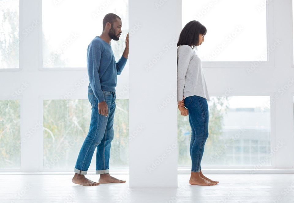 Homem atrás de uma parede querendo falar com uma mulher que está do outro lado