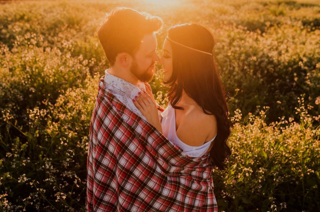 casal abraçados de forma romântica no campo ao pôr do sol