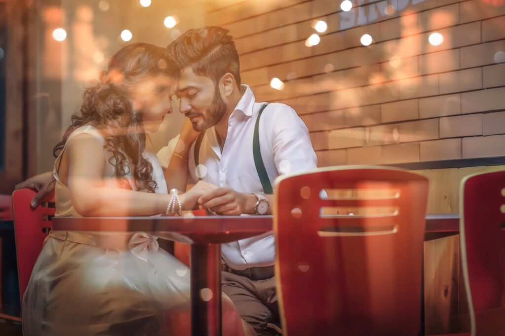 casal sentando juntos de forma romântica, em mesa durante festa