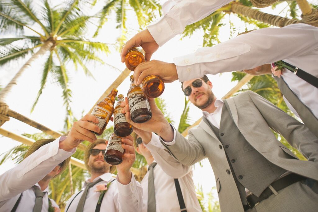 grupo de amigos em roupas sociais tomando bebidas juntos em jardim tropical