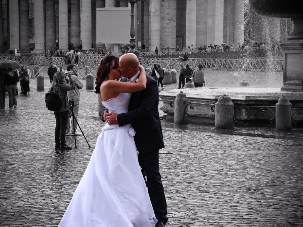 casal de noivos se beija em uma praça em Roma